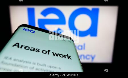 Mobiltelefon mit Webseite der Organisation International Energy Agency (IEA) auf dem Bildschirm vor dem Logo. Konzentrieren Sie sich auf die obere linke Seite des Telefondisplays. Stockfoto