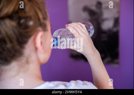 Rottweil, Deutschland. 04. März 2022. Illustration: Ein Teenager-Mädchen trinkt in ihrem Zimmer eine Flasche Wodka (Re dpa 'DAK: Depressive Kinder missbrauchen besonders oft Suchtstoffe'). Kredit: Silas Stein/dpa/Alamy Live Nachrichten Stockfoto