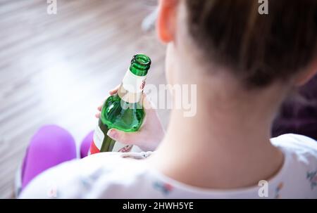 Rottweil, Deutschland. 04. März 2022. Abbildung: Ein Teenager-Mädchen hält eine Flasche Bier in ihrem Zimmer. (To dpa 'DAK: Depressive Kinder missbrauchen besonders oft Suchtstoffe'). Kredit: Silas Stein/dpa/Alamy Live Nachrichten Stockfoto