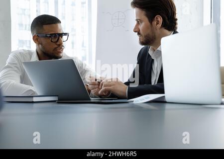 Konzentriert zwei multirassische Geschäftsleute diskutieren Online-Projekt. Stockfoto