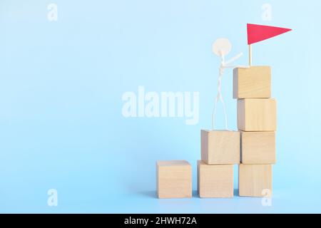 „Leiter zum Erfolg“-Konzept. Stockmann klettert mit einer roten Flagge die Treppe hinauf. Stockfoto