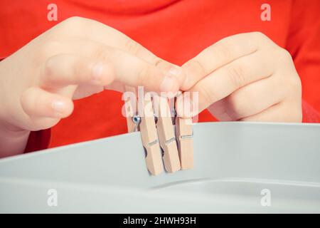 Vorschulkinder spielen mit Holzclip. Entwicklung von motorischen Fähigkeiten, Koordination und Kreativität der Kinder Stockfoto