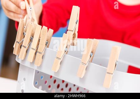 Vorschulkinder spielen mit Holzclip. Entwicklung von motorischen Fähigkeiten, Koordination und Kreativität der Kinder Stockfoto