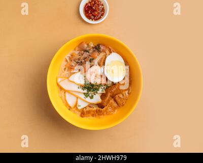 Laska in einer Schüssel mit Suppe, Chilisauce Draufsicht auf Holztisch Küche aus Südostasien Stockfoto