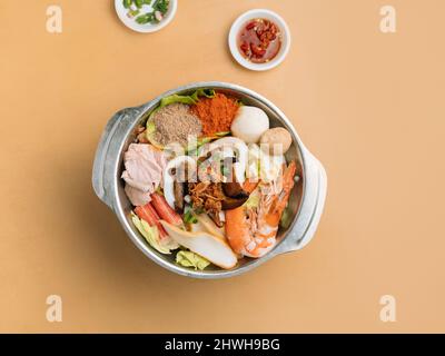 In einer Schüssel mit Suppe, Chilisauce und Frühlingszwiebeln Draufsicht auf Mala Xiao Wan aus Holz in einer Schüssel mit Chilisauce und Pulver und Frühlingszwiebeln Draufsicht auf Stockfoto