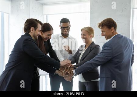 Glücklich motivierte, vielfältige Geschäftsleute, die Teamwork zeigen. Stockfoto