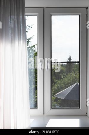 Fenster mit Tüll an einem sonnigen Tag, Vorderansicht, Fotohintergrund Stockfoto