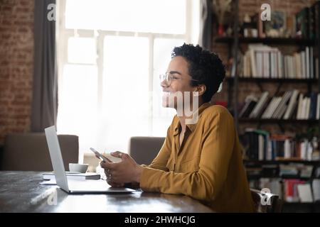 Fröhlich nachdenklich Schwarz Gadget Benutzer Frau hält Handy Stockfoto