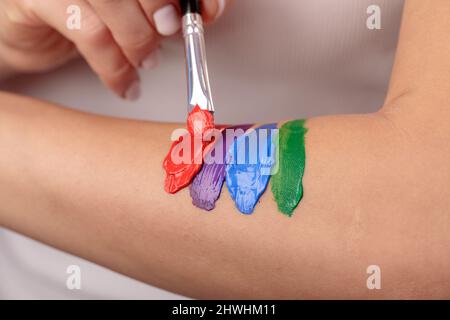 Die Abstriche der Farbe verschiedener Farben auf der weiblichen Hand Stockfoto