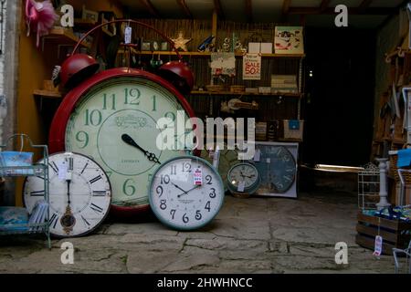 Lacock, UK-Sept 2021: Lokales Geschäft mit vielen Uhren im Vitage-Stil in verschiedenen Größen auf dem Display zusammen mit anderen kleinen Erinnerungsstücken und touristischen Geschenken. Stockfoto