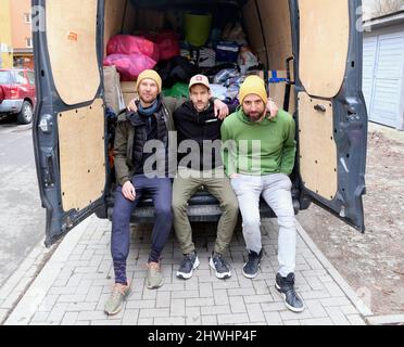 Das polnisch-ukrainische Ehepaar Szymon Makuch (C) und Oksana Shmygol, die mit viel humanitärer Hilfe nach Lemberg aufreisten. Gruppe von Freunden hilft. Stockfoto