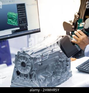Industrietechniker, der den tragbaren 3D CMM-Laserscanner mit hoher Technologie betreibt, inspiziert die Engine. Stockfoto