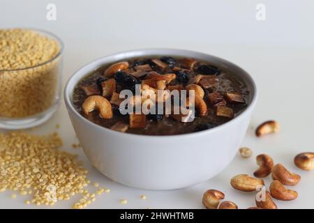 Süßer Pongal. Ein indisches süßes Gericht aus weißem Reis und gelben Moong-Linsen und Jaggery. Garniert mit ghee frittierten Cashewnüssen und Kokosnussstückchen. S Stockfoto