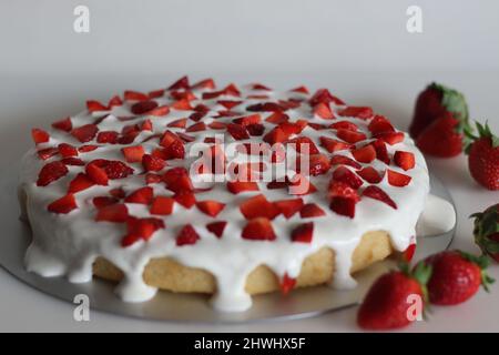 Frische Erdbeerkuchen. Biskuitkuchen mit Erdbeere und frischer Creme als Belag. Aufgenommen auf weißem Hintergrund. Stockfoto