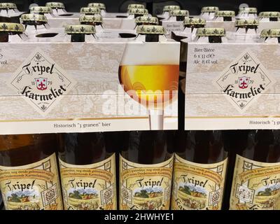 Lüttich, Belgien - März 3. 2022: Nahaufnahme von Bierflaschen mit Logo-Schriftzug der belgischen Marke Tripel karmeliet im Regal des Supermarkts Stockfoto