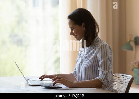 Frau macht Berechnungen auf Rechner, Rechnungen bezahlen mit Laptop Stockfoto