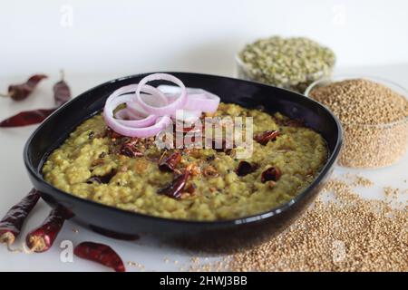 Ein Topf Zubereitung mit kodo Hirse, Mungbohnenlinse. In Indien allgemein bekannt als kodo Hirse khichdi. Aufgenommen auf weißem Hintergrund. Stockfoto