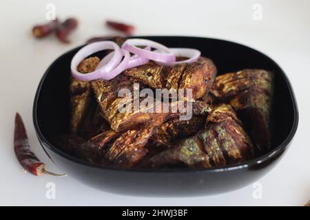 Marinierter und flacher gebratener Makrelenfisch. Eine beliebte, nicht vegetarische Beilage aus kerala-Mahlzeiten, die ayala-Fritte genannt wird. Aufgenommen auf weißem Hintergrund Stockfoto