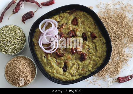 Ein Topf Zubereitung mit kodo Hirse, Mungbohnenlinse. In Indien allgemein bekannt als kodo Hirse khichdi. Aufgenommen auf weißem Hintergrund. Stockfoto