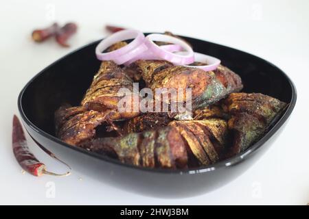 Marinierter und flacher gebratener Makrelenfisch. Eine beliebte, nicht vegetarische Beilage aus kerala-Mahlzeiten, die ayala-Fritte genannt wird. Aufgenommen auf weißem Hintergrund Stockfoto