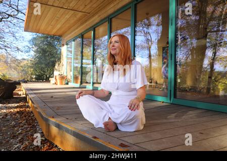 Jacqui Cooper von Beachyjax Healing Hub posiert vor ihrem neu gebauten Maloka. Jacqui ist eine erfahrene Praktizierende, die mit Geist, Körper und Spiri arbeitet Stockfoto