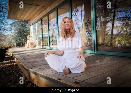 Jacqui Cooper von Beachyjax Healing Hub posiert vor ihrem neu gebauten Maloka. Jacqui ist eine erfahrene Praktizierende, die mit Geist, Körper und Spiri arbeitet Stockfoto