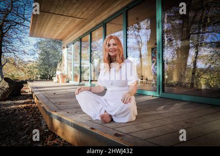 Jacqui Cooper von Beachyjax Healing Hub posiert vor ihrem neu gebauten Maloka. Jacqui ist eine erfahrene Praktizierende, die mit Geist, Körper und Spiri arbeitet Stockfoto