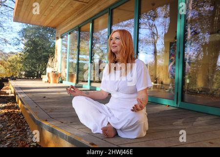 Jacqui Cooper von Beachyjax Healing Hub posiert vor ihrem neu gebauten Maloka. Jacqui ist eine erfahrene Praktizierende, die mit Geist, Körper und Spiri arbeitet Stockfoto