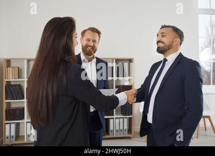 Glückliches Treffen des Firmenmanagers und Kunden im Büro, lächelnd und Händeschütteln Stockfoto