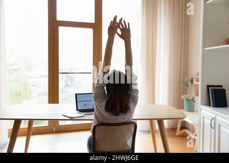 Frau erledigen Arbeit Lehnen Sie sich auf einen Stuhl mit erhobenen Armen Stockfoto