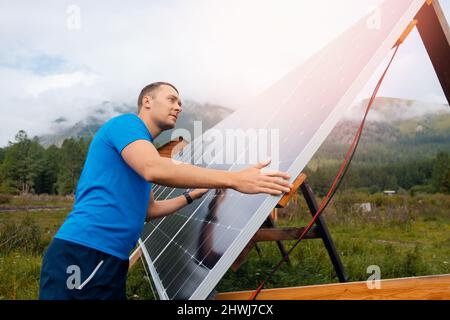 Junge männliche Ingenieur Installation und Betrieb Sonnenkollektoren. Konzept zur Vorbereitung von elektrischen Energieelementen für den Winter. Stockfoto