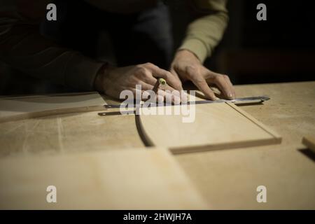 Markierung auf Lineal mit Bleistift. Zeichnen einer Linie auf dem Baum. Hände des Zimmermanns. Projekt erstellen. Stockfoto