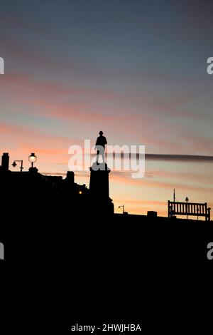 Statue von Captain James Cook in der Abenddämmerung mit Blick auf den Hafen von Whitby North Yorkshire England Stockfoto