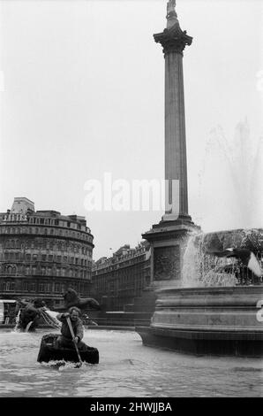 Coracle Fishermen in London. Einer der Fischer paddelt zum Interesse der Besucher sein Corakel um den Trafalgar Square Brunnen. 1.. April 1972. Stockfoto