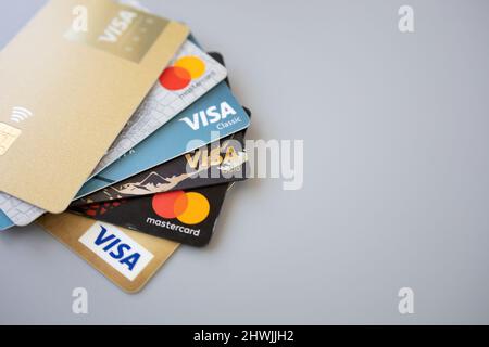 Minsk, Weißrussland 06. März 2022. Stapel von Mastercard- und Visa-Karten auf grauem Hintergrund. Online-Kreditkartenzahlung für Einkäufe beim Online-Shopping Stockfoto