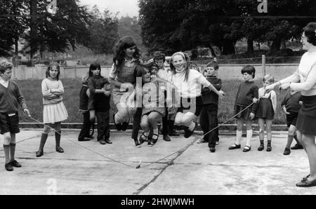 Ein junges Mädchen, das auf dem Spielplatz der Nationalschule in Donard, County Wicklow in Irland, über ein Springseil springt. 10.. Oktober 1971. Stockfoto