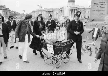 Die Schauspielerin und ehemalige Model Madeline Smith wurde vom Gesetz in Gesellschaft mit einem Dodo in einem Kinderwagen auf dem Trafalgar Square zwangsweise weiterbewegt. Sie wirbt für einen Verkauf seltener, gefüllter Naturkundemuster für einen Freund, der die British Natural History Company leitet. Hier ist sie mit Digby, dem Dodo auf dem Trafalgar Square, abgebildet, der von drei Polizisten eskortiert wird. 24.. September 1972. *** Ortsüberschrift *** Maddy Smith Stockfoto