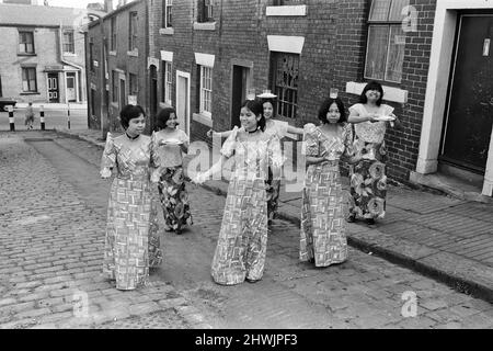 Frauen aus Manila, die in einer Mühle in Rochdale, Lancashire, arbeiten, zeigen in den Kopfsteinpflasterstraßen von Rochdale nationale Tänze. 20.. Juli 1972. Stockfoto