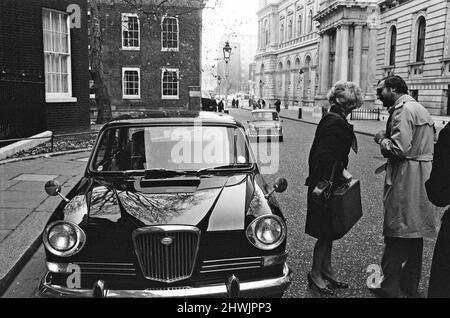 Der Umweltminister Geoffrey Rippon hat heute in den Büros des Ministerministeriums in der Marsham Street einen elektrisch betriebenen Mini geliefert. Seine erste offizielle Reise mit dem mit Chauffeur angetriebenen Mini-Reisenden war in die Downing Street, um den Premierminister zu sehen, wo Frau Thatcher, die gerade in ihrer großen Limousine angekommen war, für einen Moment pausierte, als sie den Mini in der Downing Street ankommen sah. Bild aufgenommen am 21.. November 1973 Stockfoto