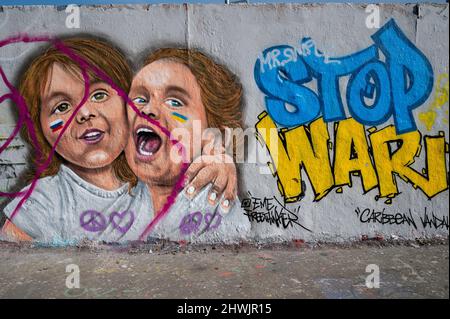 02.03.2022, Berlin, Deutschland, Europa - Ein Graffiti der Künstlerin EME Freethinker auf der Berliner Mauer im Berliner Mauerpark mit der Botschaft Stop war. Stockfoto