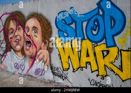 02.03.2022, Berlin, Deutschland, Europa - Ein Graffiti der Künstlerin EME Freethinker auf der Berliner Mauer im Berliner Mauerpark mit der Botschaft Stop war. Stockfoto