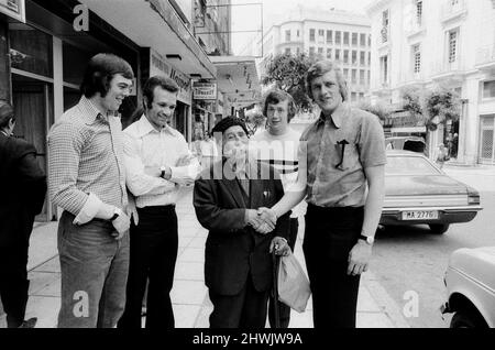 Die Spieler von Leeds United treffen auf einen Einheimischen mit einem riesigen Schnurrbart, der vor dem EM-Finale 1973 gegen AC Mailand im Kaftanzoglio-Stadion in Thessaloniki, Griechenland, durch die Stadt Salonike spazierengeht. Leeds verlor 0-1 im Finale nach einigen umstrittenen Entscheidungen des griechischen Schiedsrichters Christos Michas. 15. Mai 1973. Stockfoto