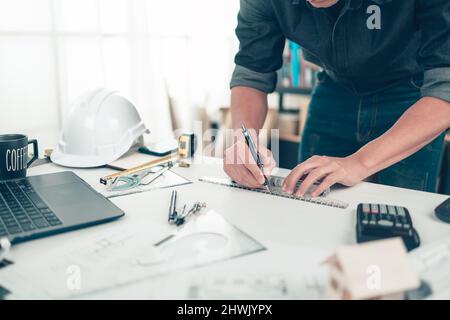 Architekt Ingenieur verwenden Stift und Mini-T-Folie Zeichnung Design arbeiten auf bueprint. Hausplanung Design und Baukonzept. Stockfoto