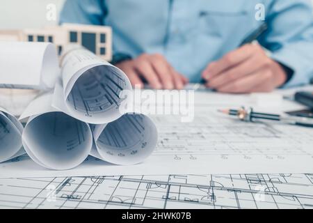 Architekt rollt und plant auf dem Tisch und Architekt Ingenieur verwenden Stift Zeichnung Design arbeiten auf bueprint. Haus Planung Design und Bau conce Stockfoto