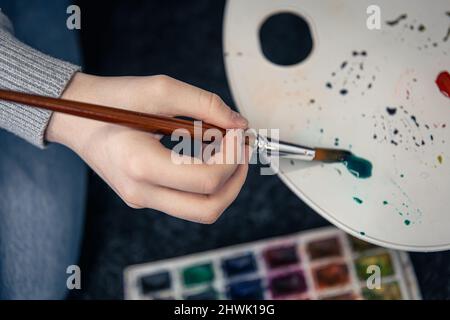 Nahaufnahme, eine Frau malt mit einer Palette. Stockfoto