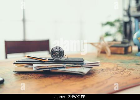 Magnetischer Kompass auf dem Buch und Straßenkarte innen auf der Weltkarte. Reise-, Abenteuer- und Entdeckungskonzept. Stockfoto