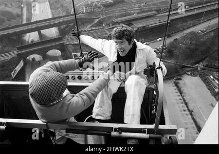 Der Schauspieler Michael Crawford fotografierte während der Dreharbeiten im Station House, einem 200 Meter hohen Gebäude an der North Circular Road in London mit dem Stuntman Derek Ware für die BBC-Comedy-Serie „Some Mothers do Ave EM“.10.. März 1973. Stockfoto