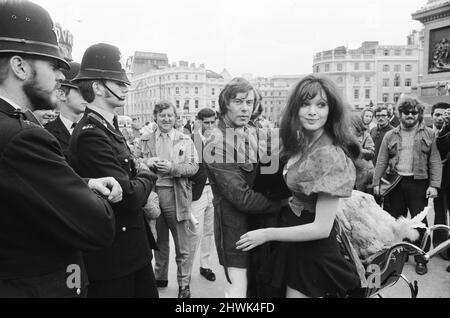 Die Schauspielerin und ehemalige Model Madeline Smith wurde vom Gesetz in Gesellschaft mit einem Dodo in einem Kinderwagen auf dem Trafalgar Square zwangsweise weiterbewegt. Sie wirbt für einen Verkauf seltener, gefüllter Naturkundemuster für einen Freund, der die British Natural History Company leitet. Hier ist sie mit Digby, dem Dodo auf dem Trafalgar Square, abgebildet, der von drei Polizisten eskortiert wird. 24.. September 1972. *** Ortsüberschrift *** Maddy Smith Stockfoto