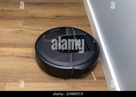 Ein moderner Roboter-Staubsauger, der auf Vinylplatten läuft, ein autonomer Reinigungsroboter. Stockfoto