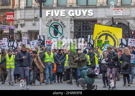 London, Großbritannien. März 2022. Eine große Menschenmenge versammelt sich vor einem fünf-Jungs-Restaurant im Zentrum von London während eines Antikriegsprotests, der von der Stop the war Coalition und der Kampagne für nukleare Abrüstung organisiert wurde. Demonstranten tragen gelbe Sicherheitswesten und Plakate mit Friedenssymbolen und Slogans wie "NEIN ZUM KRIEG" und "STOPPT DIE KRIEGSKOALITION". Stoppen Sie den Krieg in der Ukraine und keinen protestmarsch der NATO-Expansion von der BBC zum Trafalgar-Platz. Penelope Barritt/Alamy Live News Stockfoto
